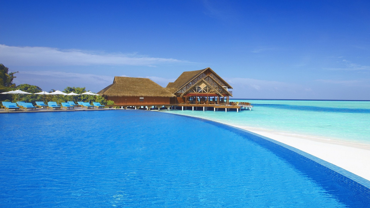 Maison en Bois Brune Sur la Mer Bleue Sous le Ciel Bleu Pendant la Journée. Wallpaper in 1280x720 Resolution