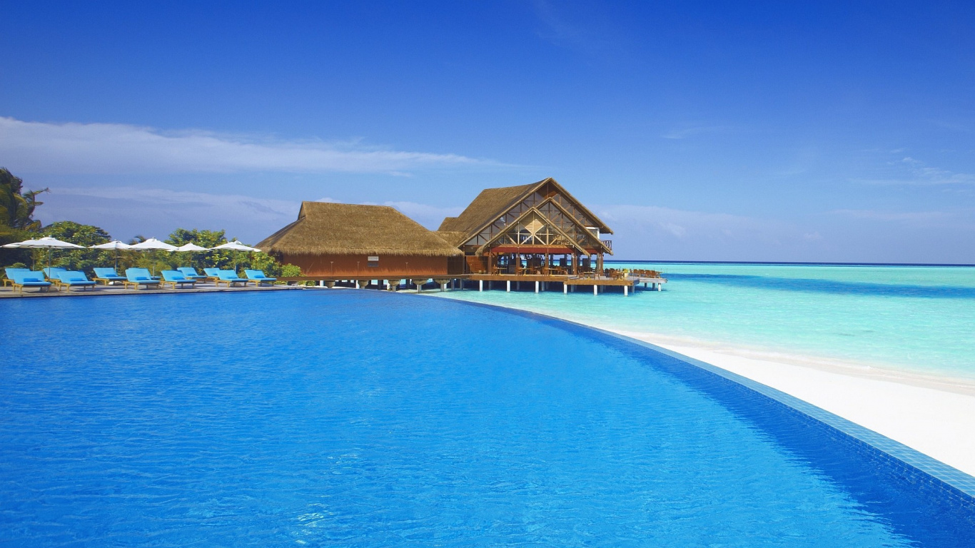 Braunes Holzhaus am Blauen Meer Unter Blauem Himmel Tagsüber. Wallpaper in 1366x768 Resolution