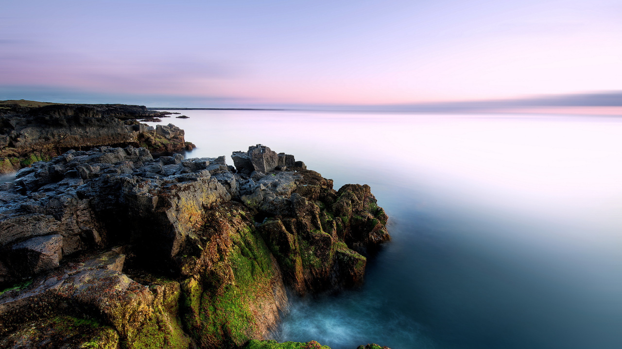 Brown and Green Rock Formation Beside Body of Water. Wallpaper in 1280x720 Resolution