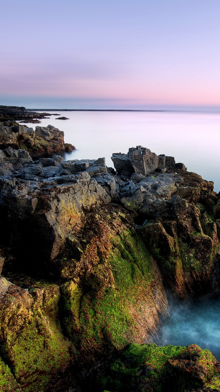 Brown and Green Rock Formation Beside Body of Water. Wallpaper in 720x1280 Resolution