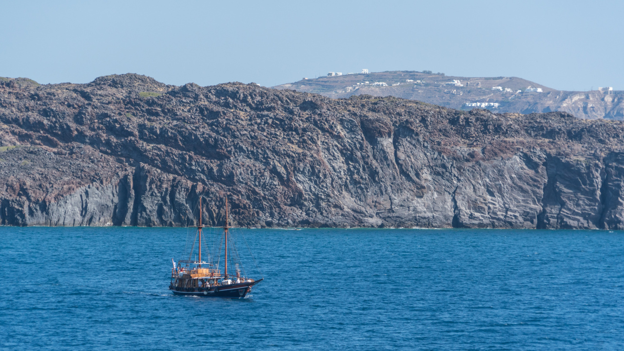 Brown Boat on Blue Sea Near Brown Mountain During Daytime. Wallpaper in 1280x720 Resolution