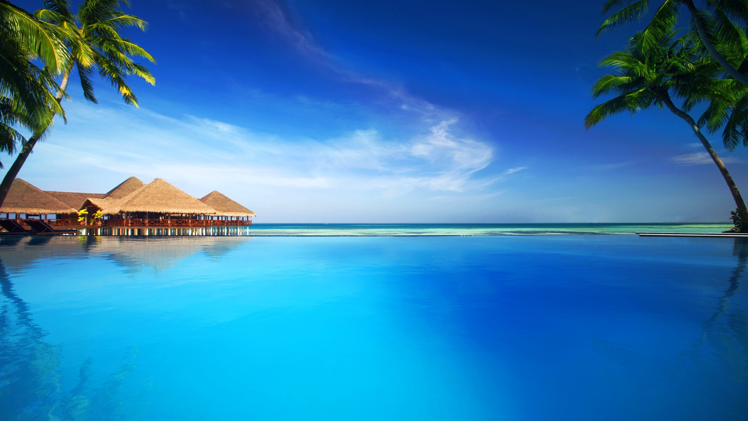 Brown Wooden House on Blue Sea Under Blue Sky During Daytime. Wallpaper in 2560x1440 Resolution