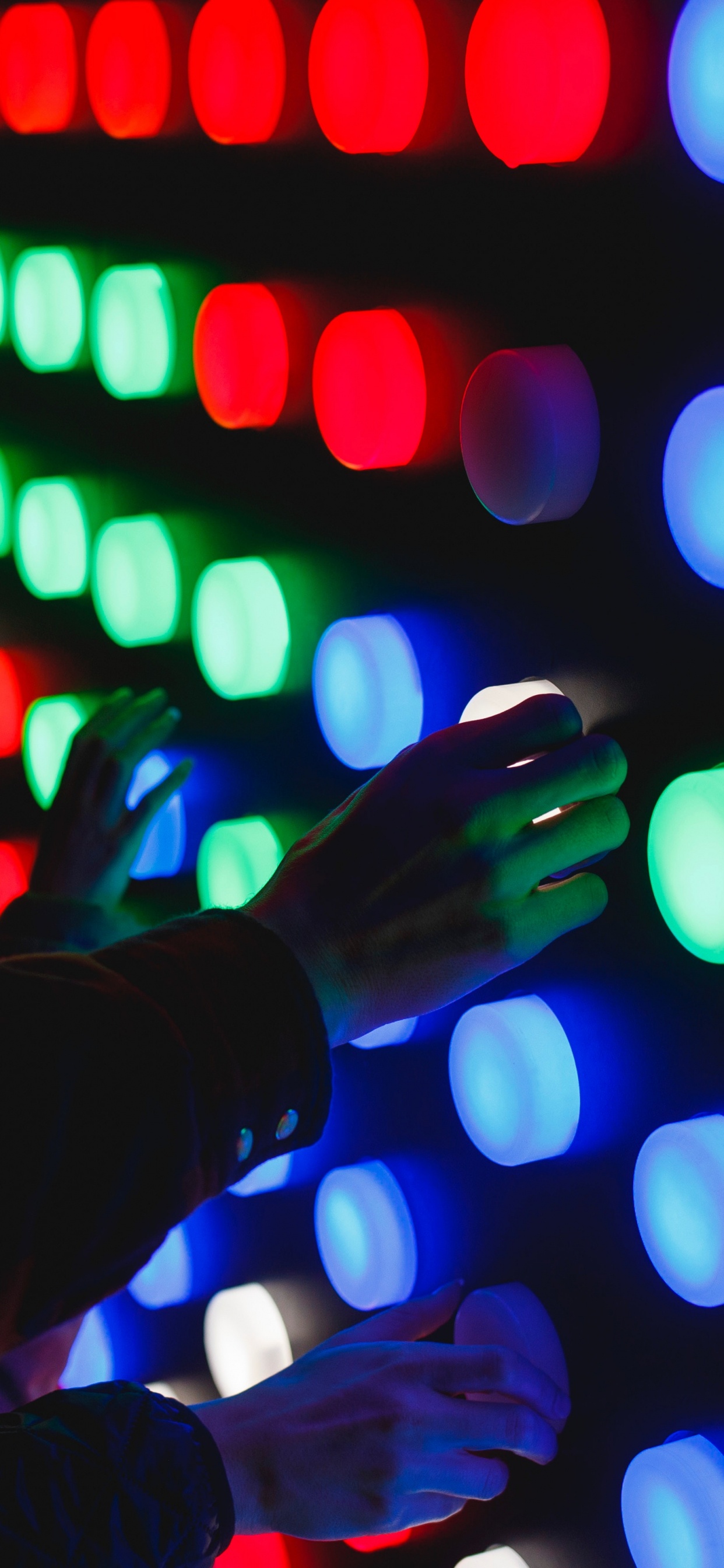 Persons Hand With Green Light Bokeh. Wallpaper in 1242x2688 Resolution