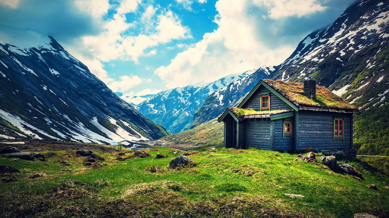 Brown Wooden House on Green Grass Field Near Mountains Under Blue Sky During Daytime. Wallpaper in 1280x720 Resolution