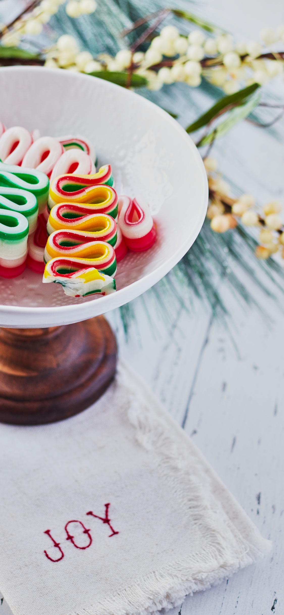 Weißer Runder Keramikteller Mit Bunten Bonbons. Wallpaper in 1125x2436 Resolution