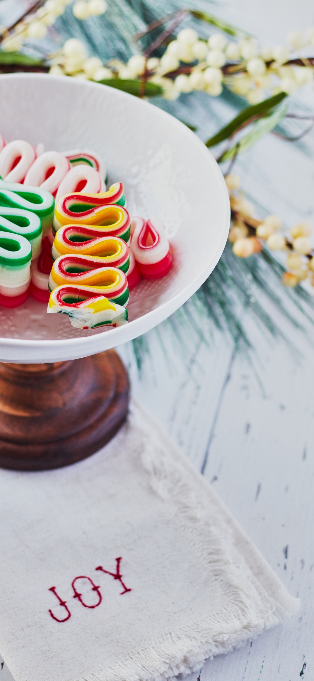 Weißer Runder Keramikteller Mit Bunten Bonbons. Wallpaper in 1242x2688 Resolution