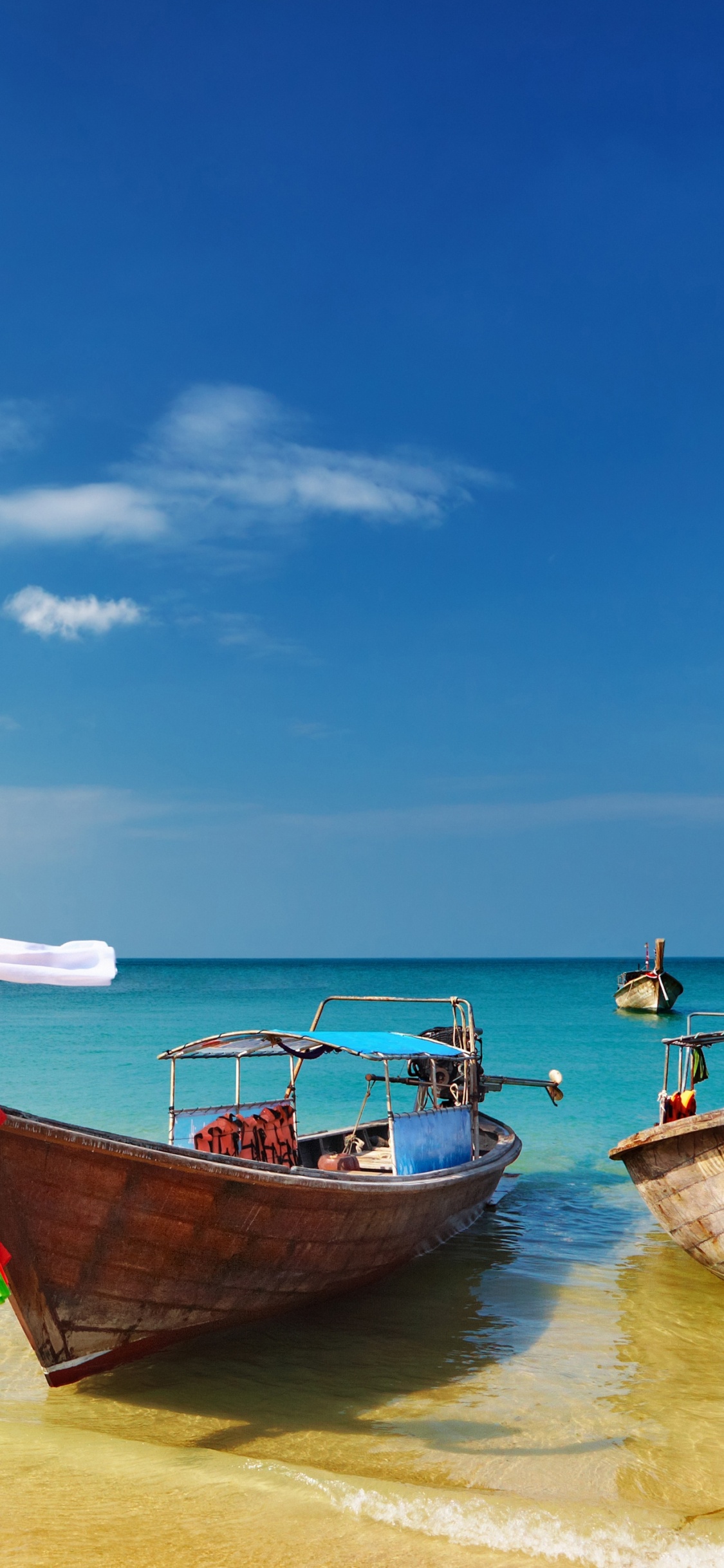 Brown Boat on Sea Shore During Daytime. Wallpaper in 1125x2436 Resolution