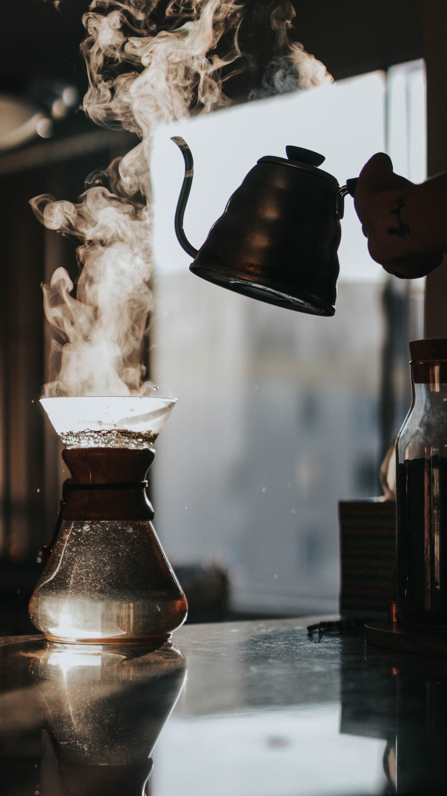 Person Pouring Water From Brown Ceramic Teapot to Clear Glass Pitcher. Wallpaper in 1440x2560 Resolution