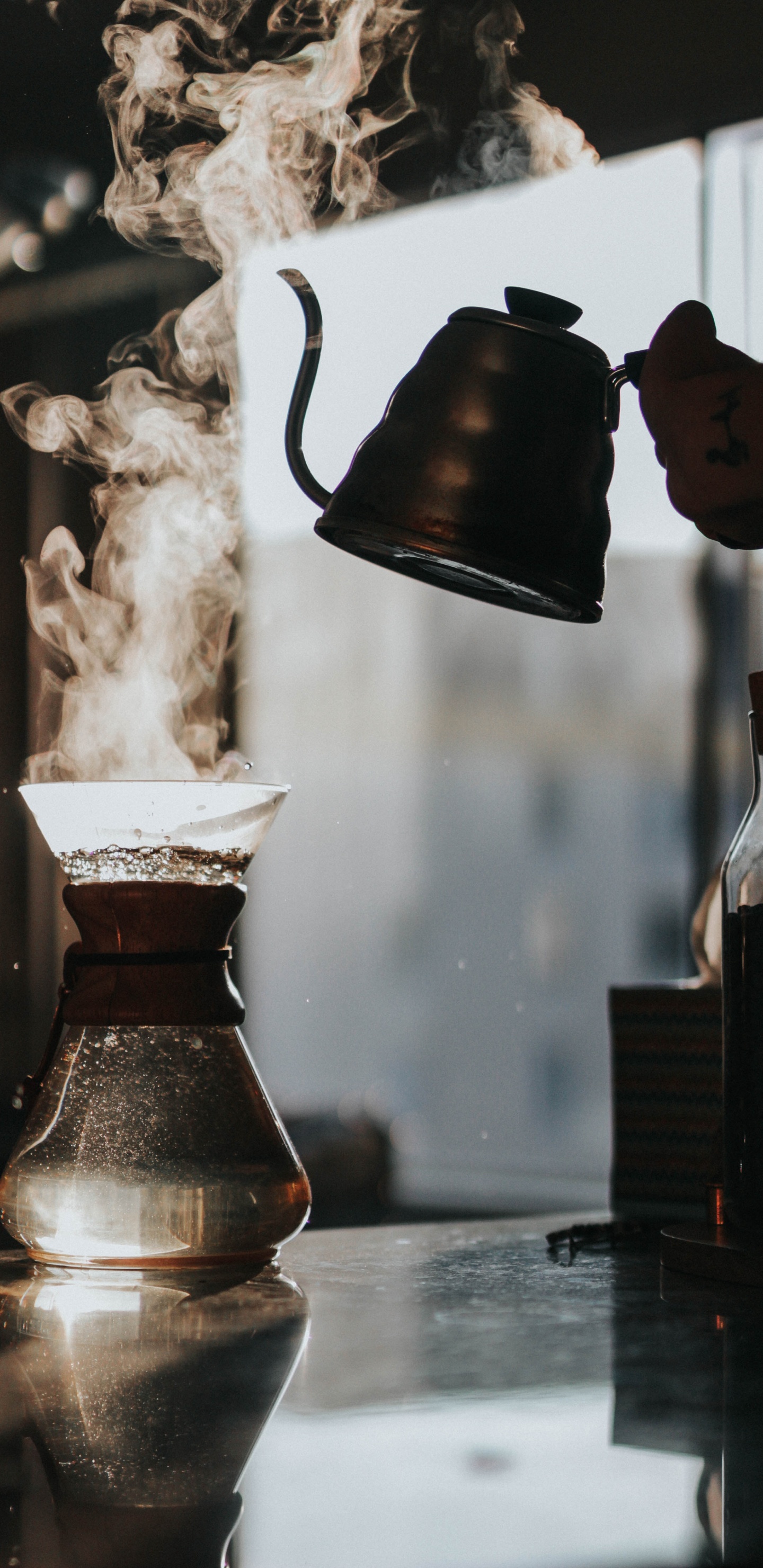 Person Pouring Water From Brown Ceramic Teapot to Clear Glass Pitcher. Wallpaper in 1440x2960 Resolution