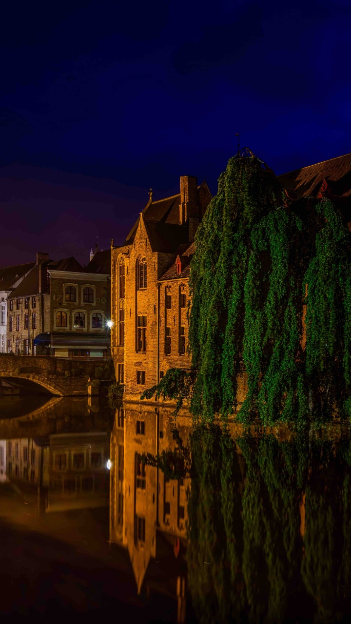 Brown Concrete Building Near Body of Water During Night Time. Wallpaper in 720x1280 Resolution