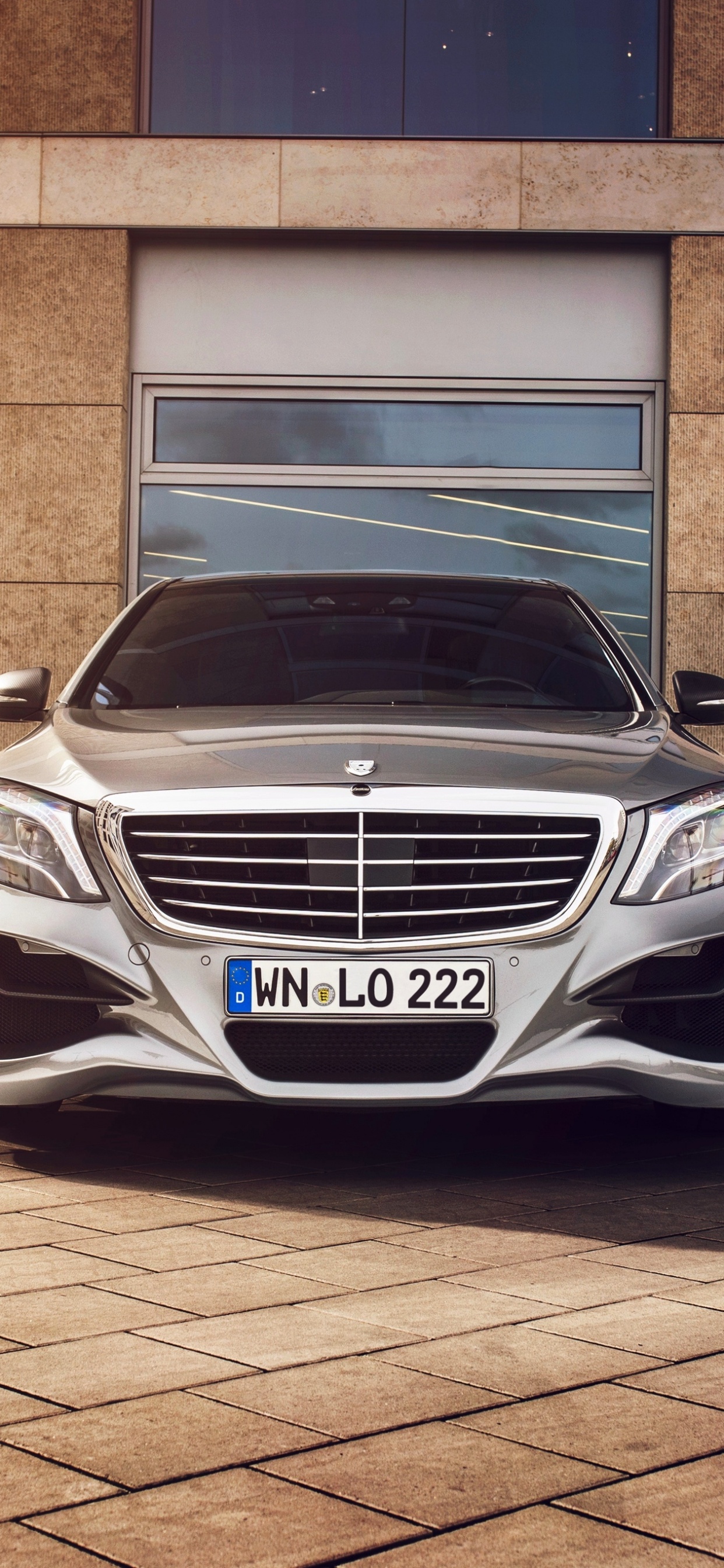 White Mercedes Benz Car Parked Beside Brown Brick Wall. Wallpaper in 1242x2688 Resolution