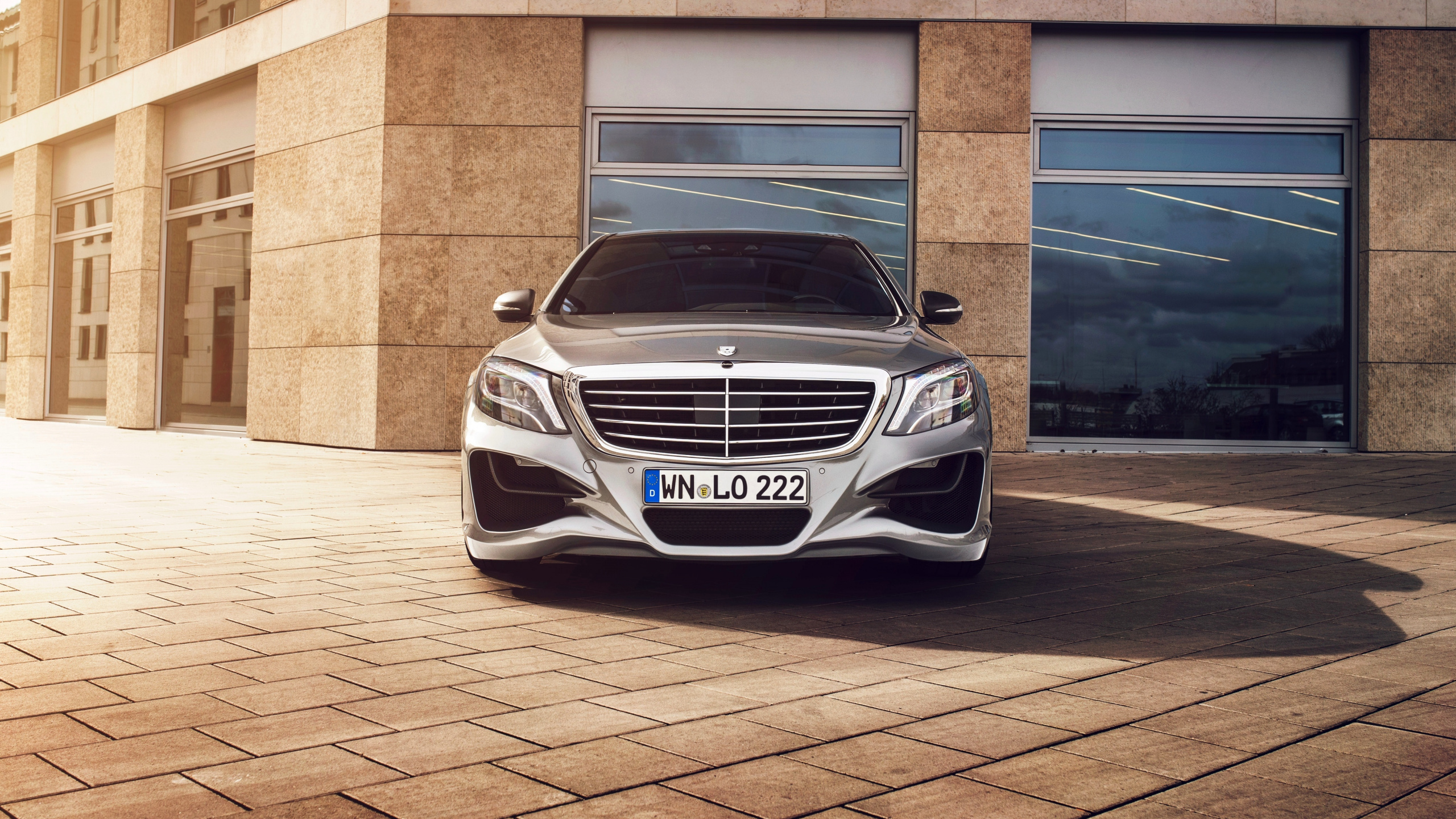 White Mercedes Benz Car Parked Beside Brown Brick Wall. Wallpaper in 2560x1440 Resolution