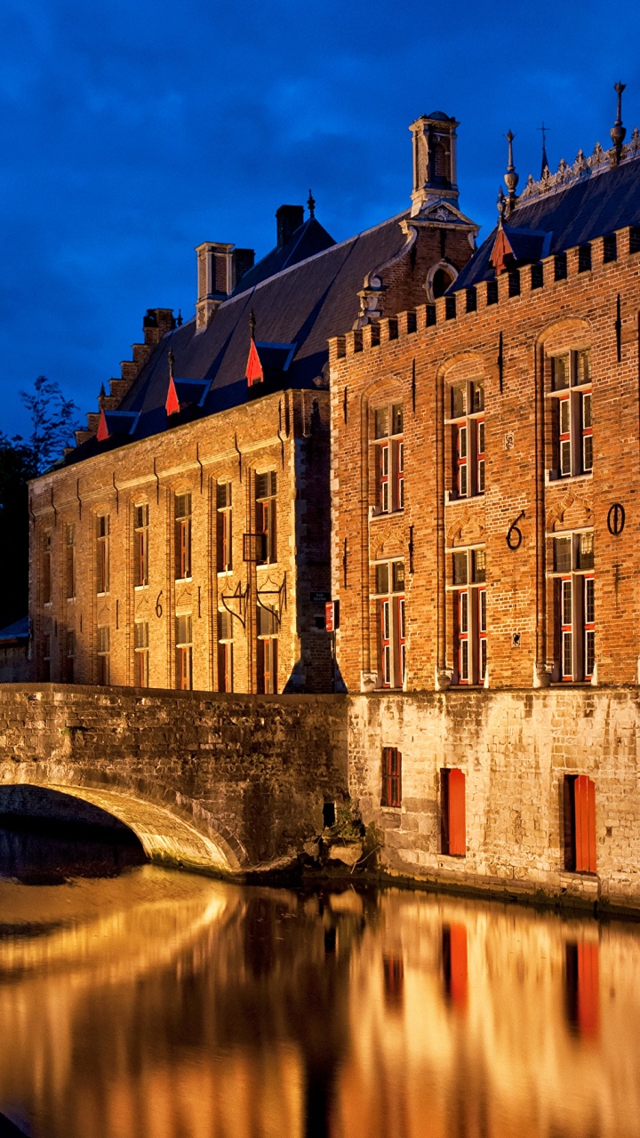 Braunes Betongebäude in Der Nähe Von Gewässern Während Der Nacht. Wallpaper in 720x1280 Resolution