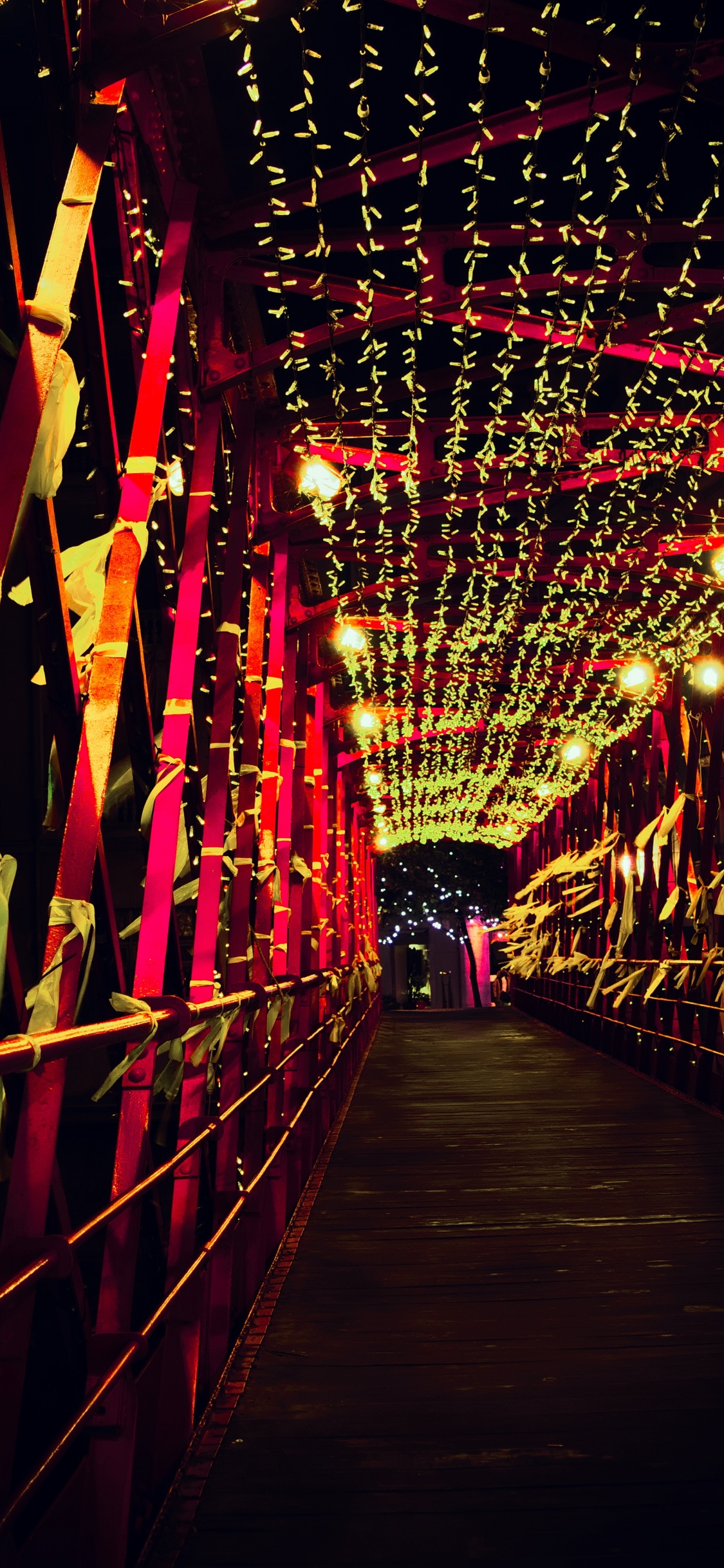 Rote Lichterketten Auf Brauner Holzbrücke. Wallpaper in 1125x2436 Resolution
