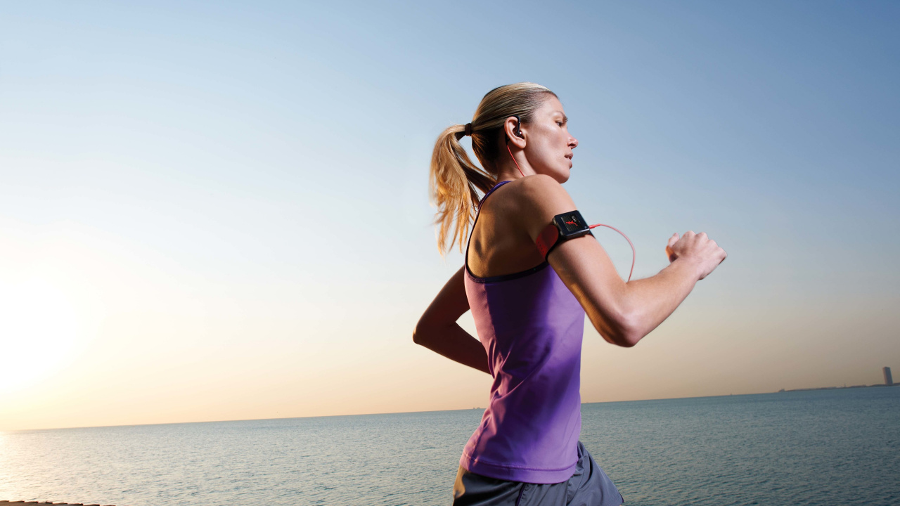 Woman in Purple Tank Top and Blue Denim Shorts Standing on Beach During Daytime. Wallpaper in 1280x720 Resolution