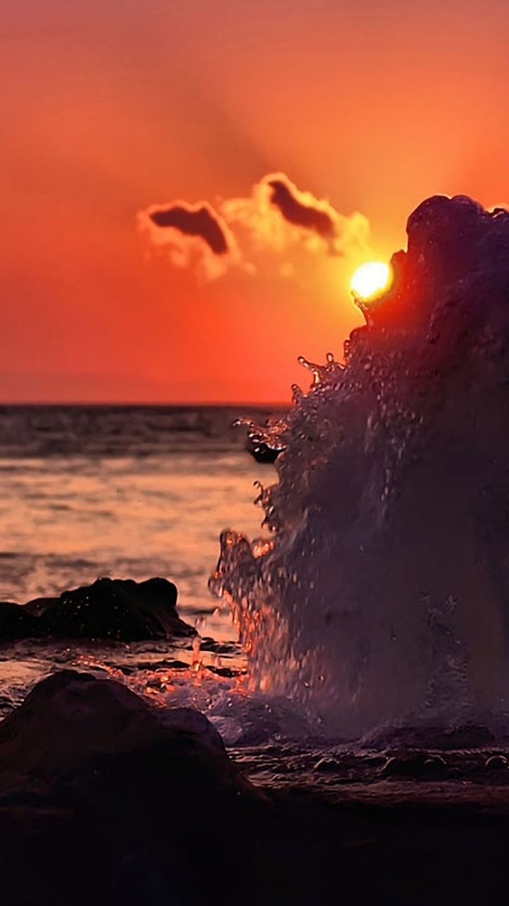 Silueta de Persona de Pie Sobre Una Roca Cerca Del Cuerpo de Agua Durante la Puesta de Sol. Wallpaper in 720x1280 Resolution