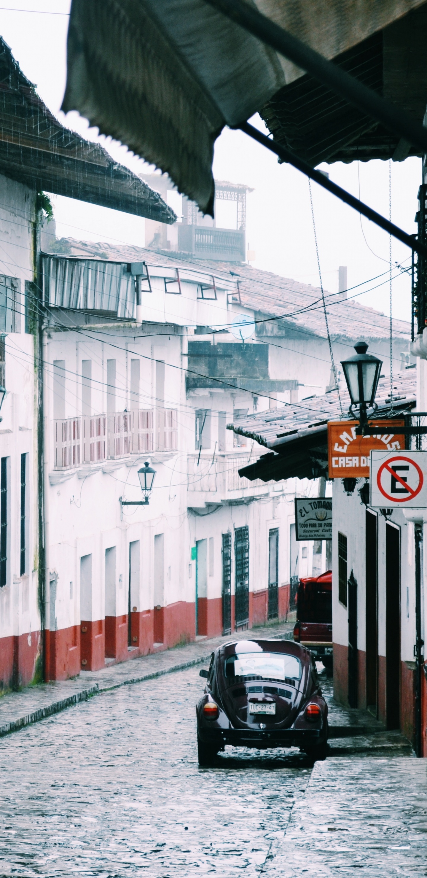 Schwarzer Motorroller, Der Tagsüber Neben Dem Weißen Und Roten Gebäude Geparkt Ist. Wallpaper in 1440x2960 Resolution