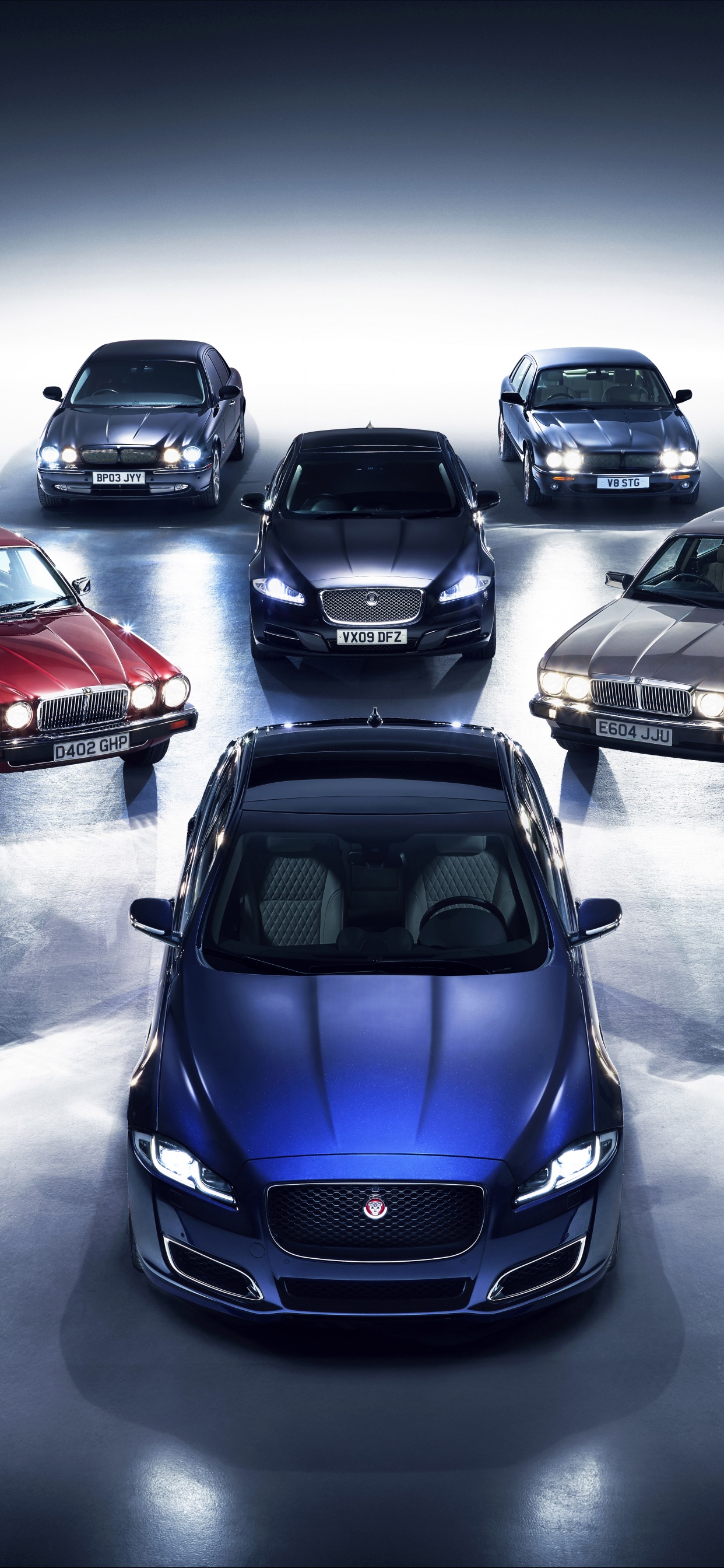 Blue Bmw Car Beside Red and Yellow Cars. Wallpaper in 1242x2688 Resolution