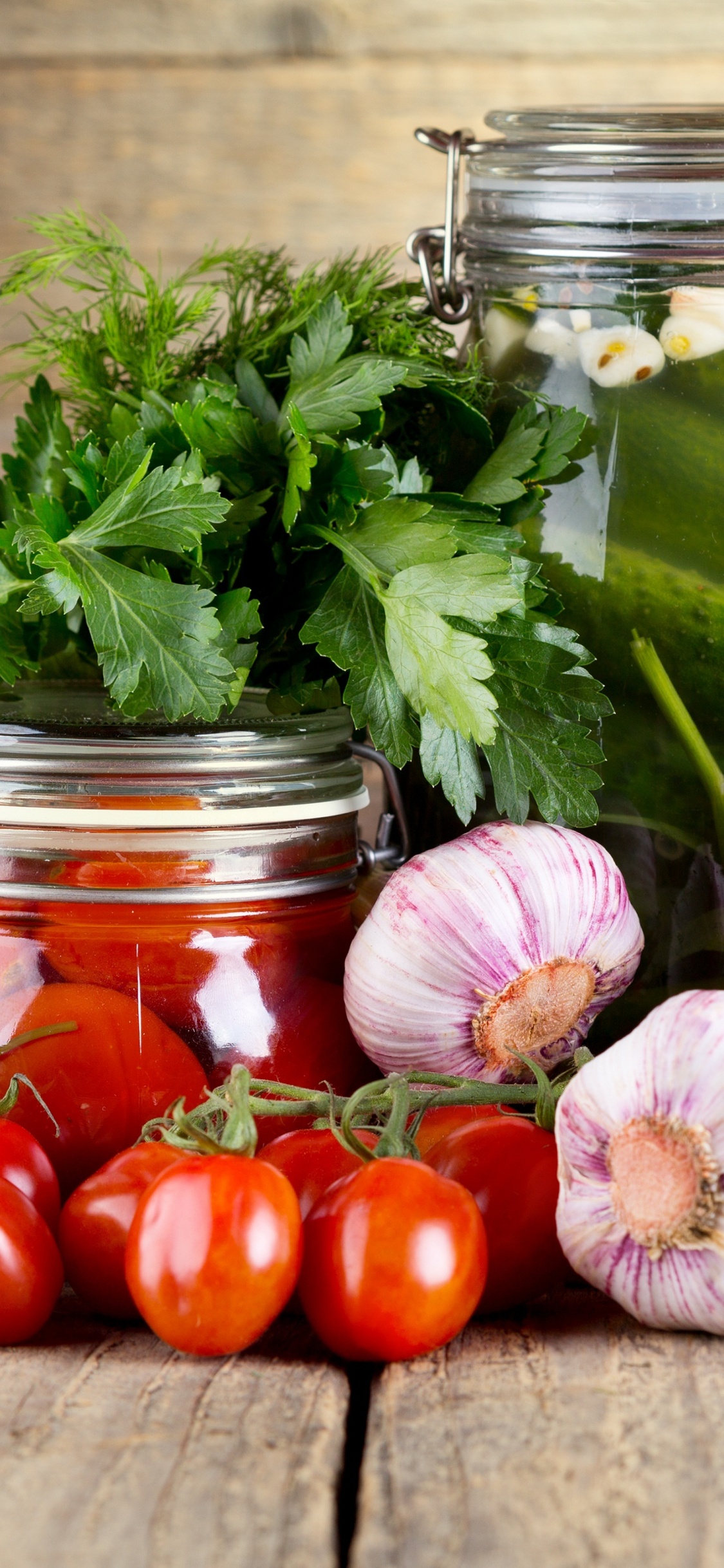 Red Tomatoes and Green Leaves in Clear Glass Jar. Wallpaper in 1125x2436 Resolution