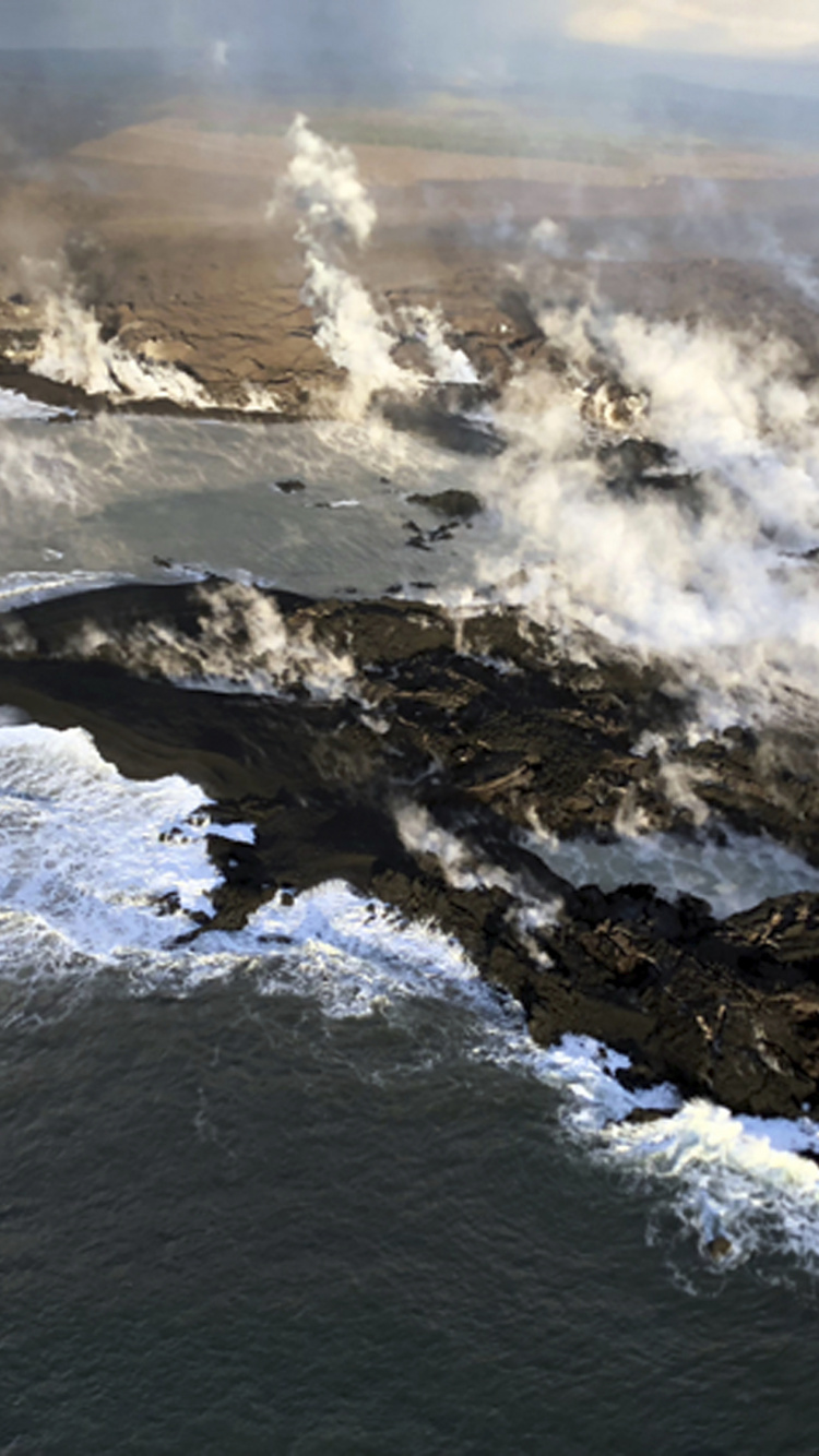 Les Vagues de L'océan S'écrasent Sur la Formation Rocheuse Pendant la Journée. Wallpaper in 750x1334 Resolution