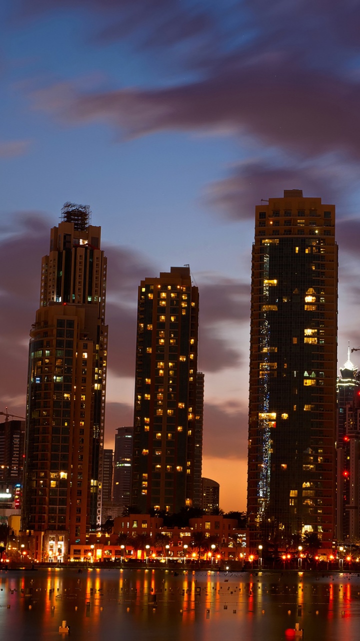 City Skyline Across Body of Water During Night Time. Wallpaper in 720x1280 Resolution