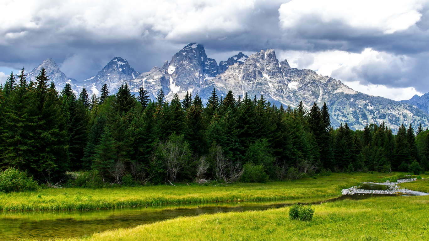 Green Grass Field Near Trees and Snow Covered Mountain During Daytime. Wallpaper in 1366x768 Resolution