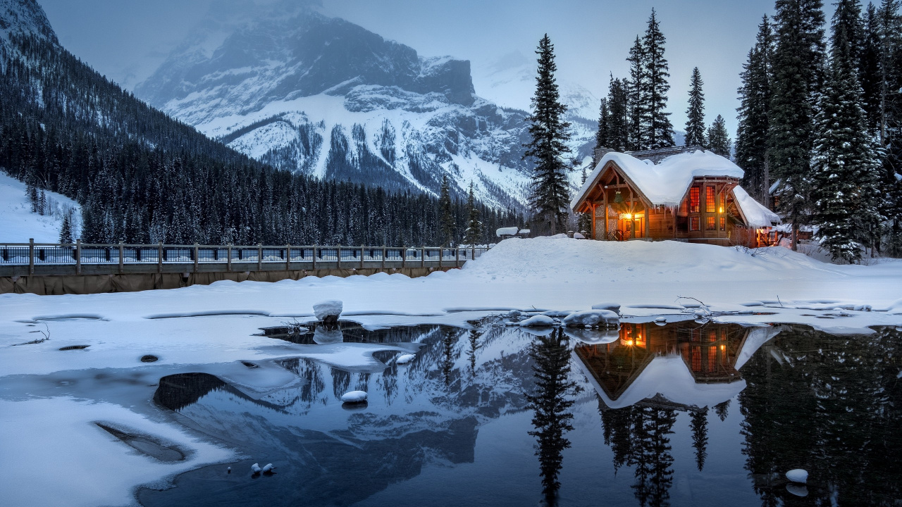 Maison en Bois Marron Sur un Sol Couvert de Neige Près de la Montagne Couverte de Neige Pendant la Journée. Wallpaper in 1280x720 Resolution