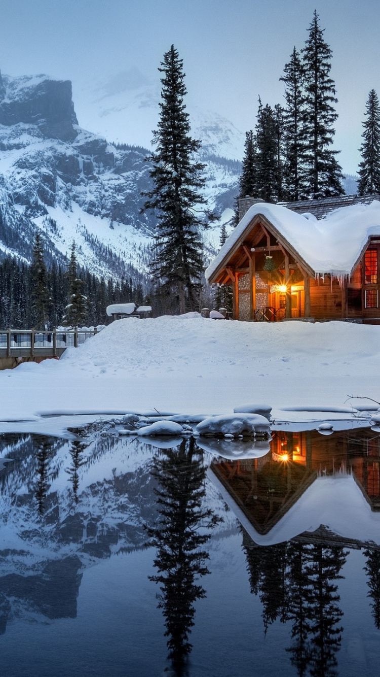 Brown Wooden House on Snow Covered Ground Near Snow Covered Mountain During Daytime. Wallpaper in 750x1334 Resolution
