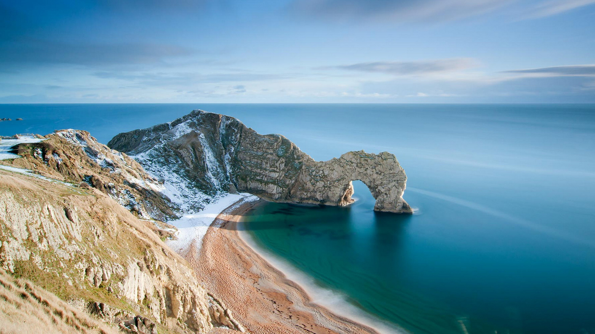 Brown Rocky Mountain Beside Blue Sea Under Blue Sky During Daytime. Wallpaper in 1920x1080 Resolution