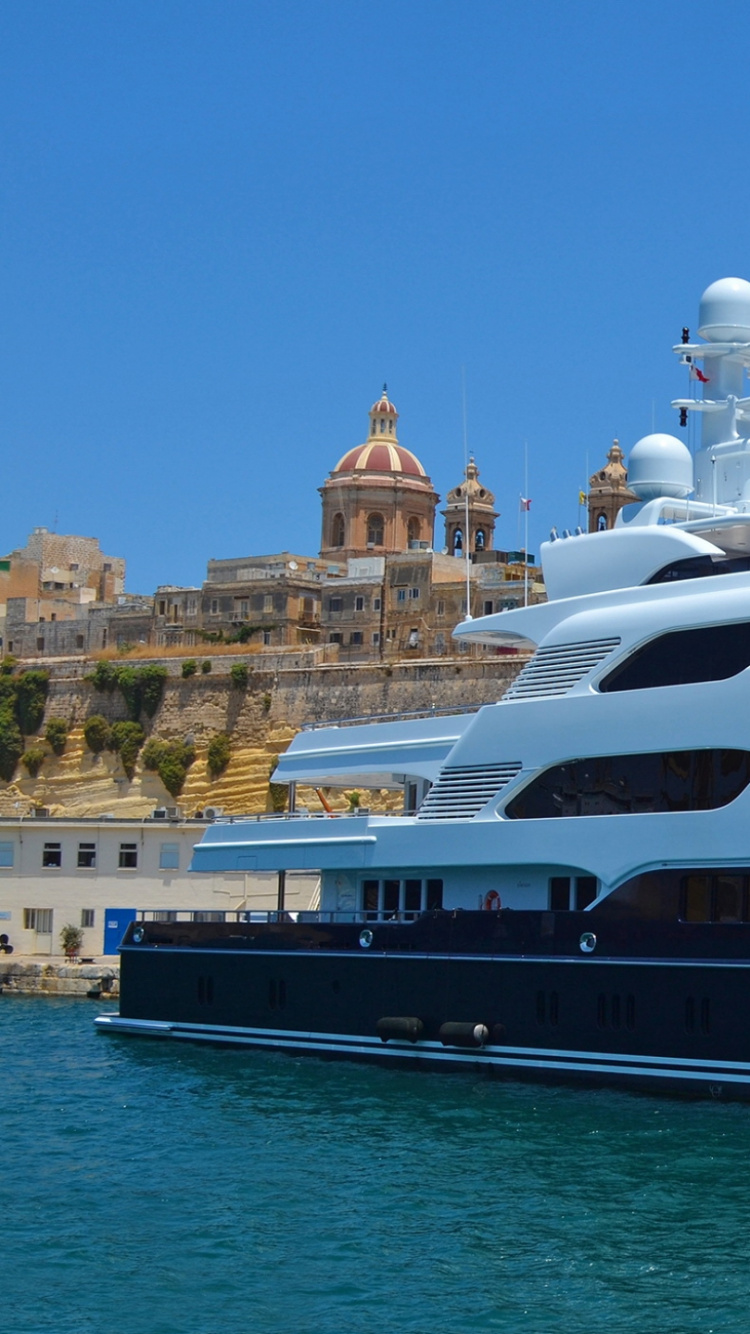 Weißes Und Schwarzes Boot Auf Dem Wasser in Der Nähe Von Gebäuden Tagsüber. Wallpaper in 750x1334 Resolution