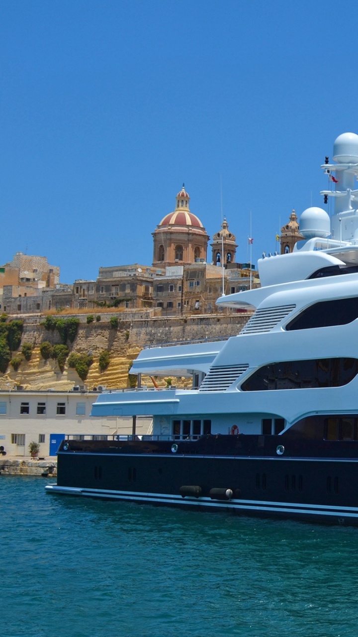 Barco Blanco y Negro Sobre el Agua Cerca de Los Edificios Durante el Día. Wallpaper in 720x1280 Resolution