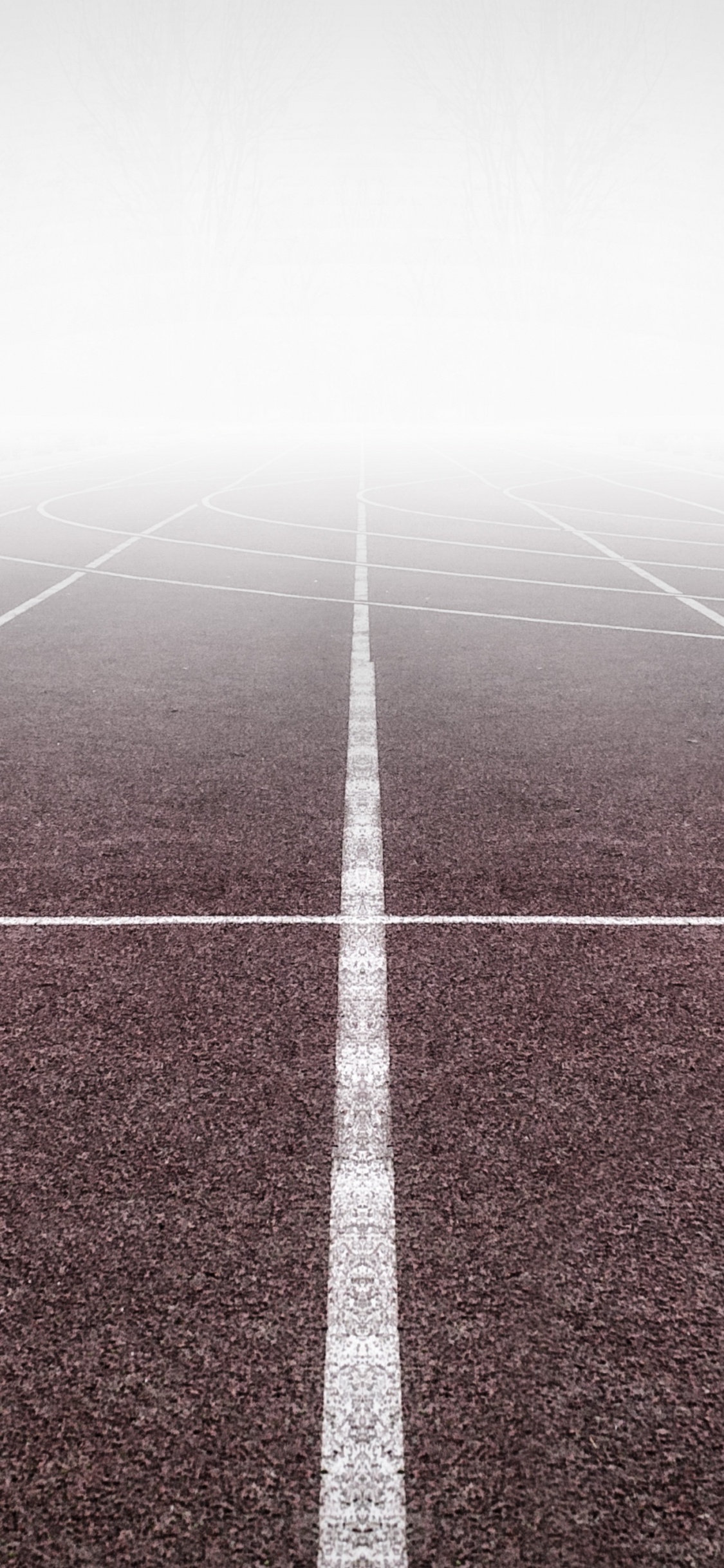 White Arrow Sign on Green and White Track Field. Wallpaper in 1125x2436 Resolution
