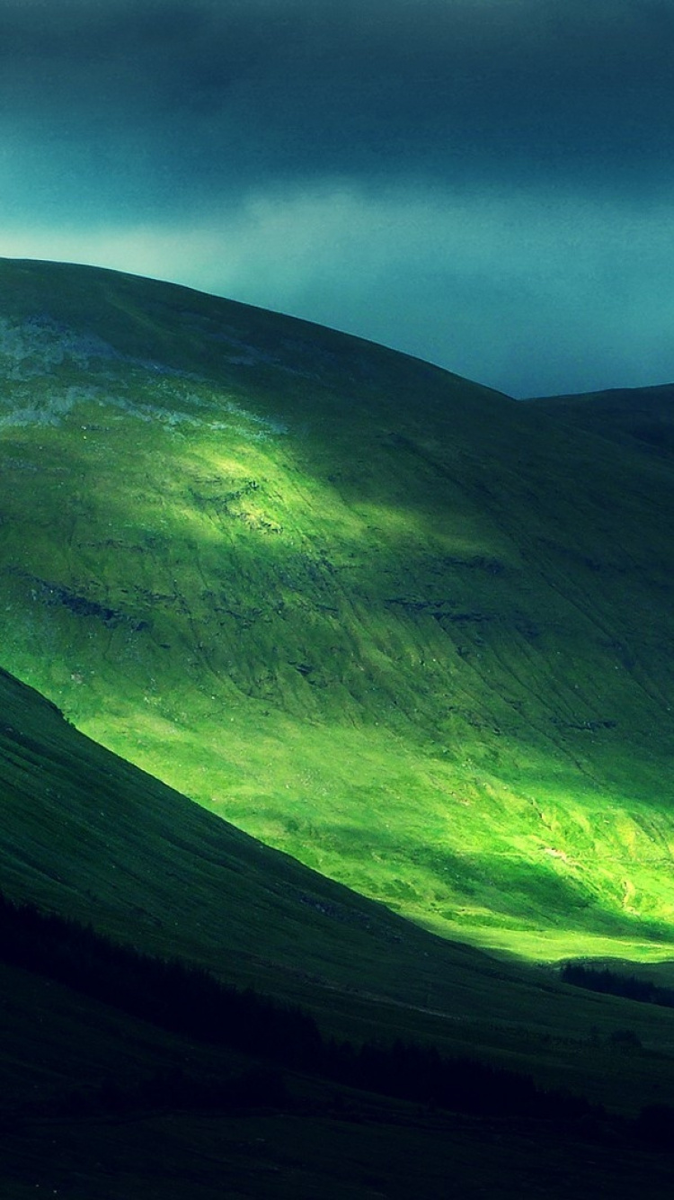 Grüner Und Schwarzer Berg Unter Grauen Wolken. Wallpaper in 750x1334 Resolution