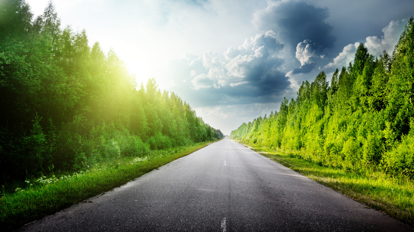 Gray Concrete Road Between Green Grass Field Under White Clouds and Blue Sky During Daytime. Wallpaper in 1366x768 Resolution