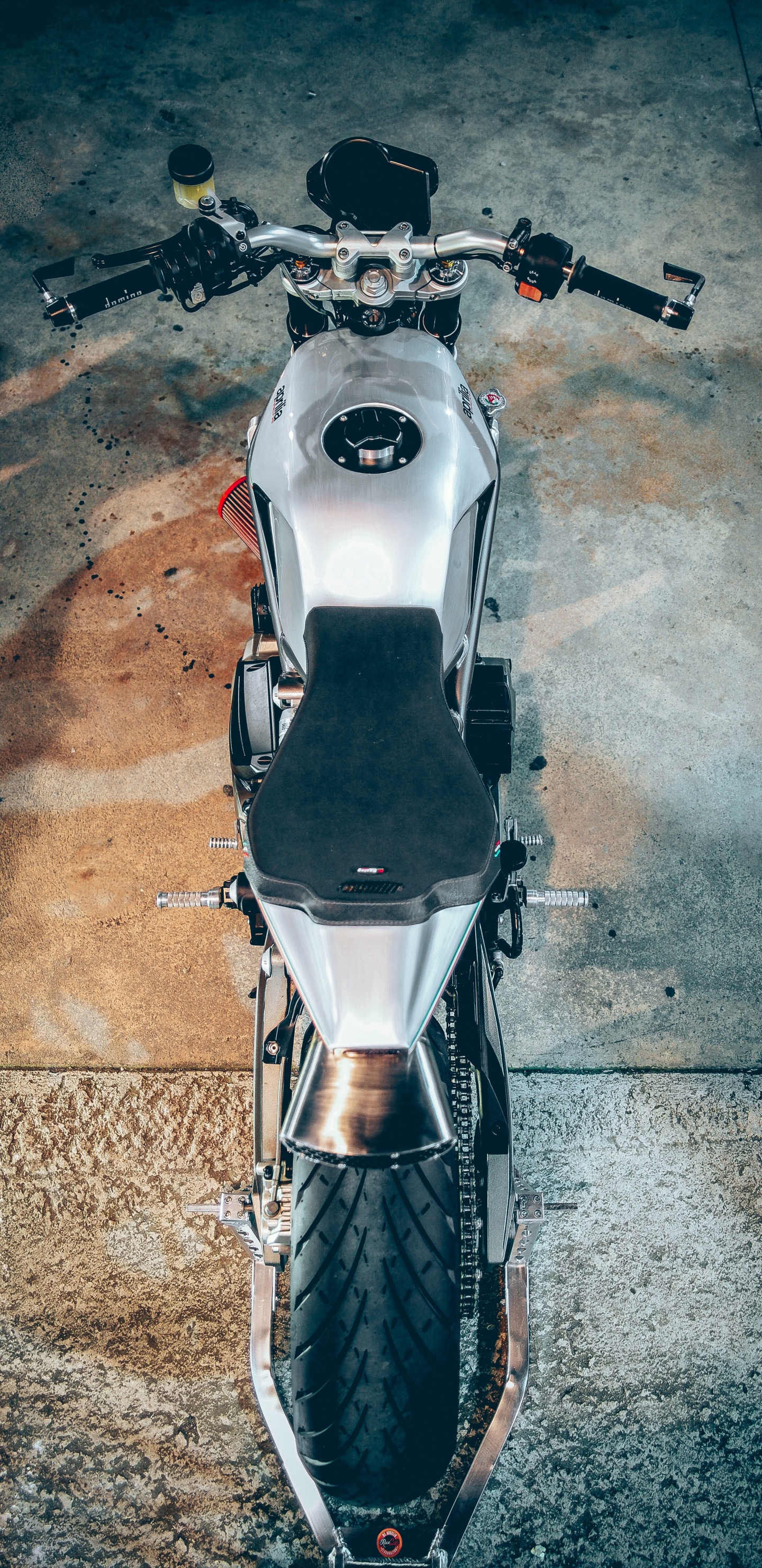 Moto Blanche et Noire Sur Sol en Béton Gris. Wallpaper in 1440x2960 Resolution