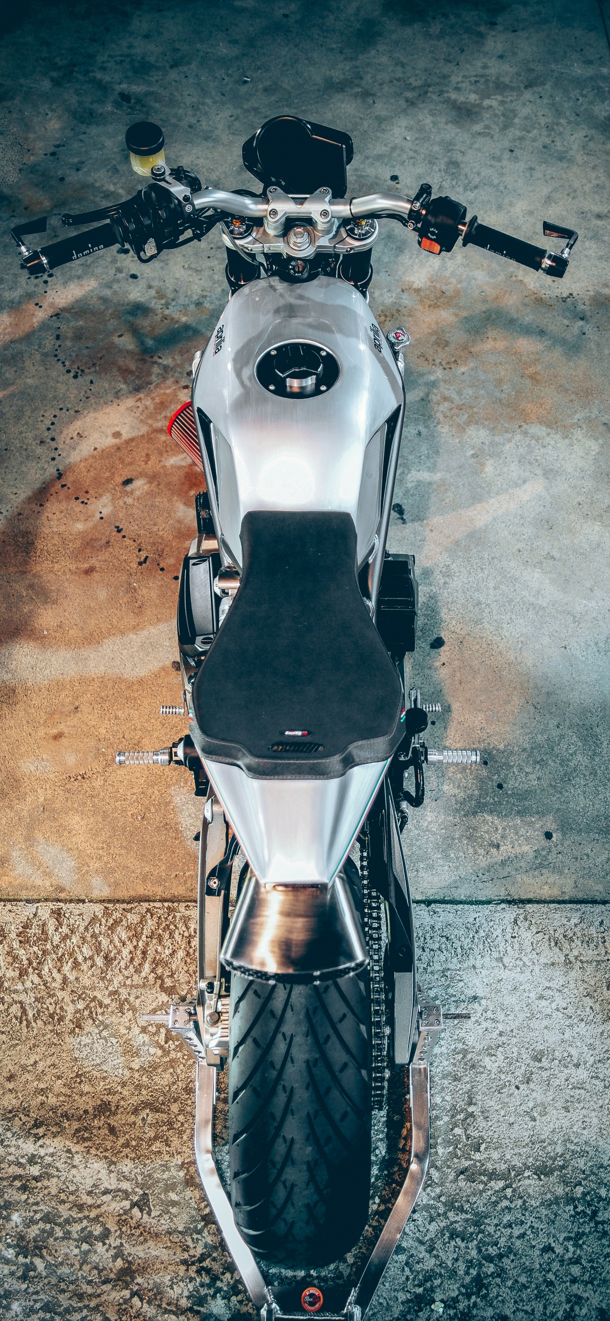 Weißes Und Schwarzes Motorrad Auf Grauem Betonboden. Wallpaper in 1242x2688 Resolution