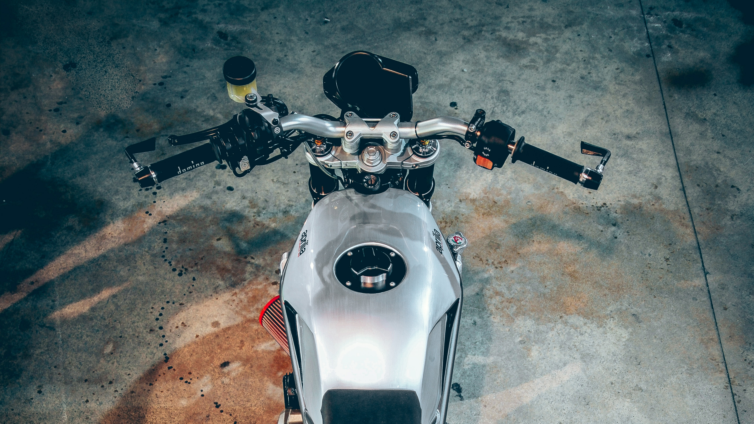 Weißes Und Schwarzes Motorrad Auf Grauem Betonboden. Wallpaper in 2560x1440 Resolution