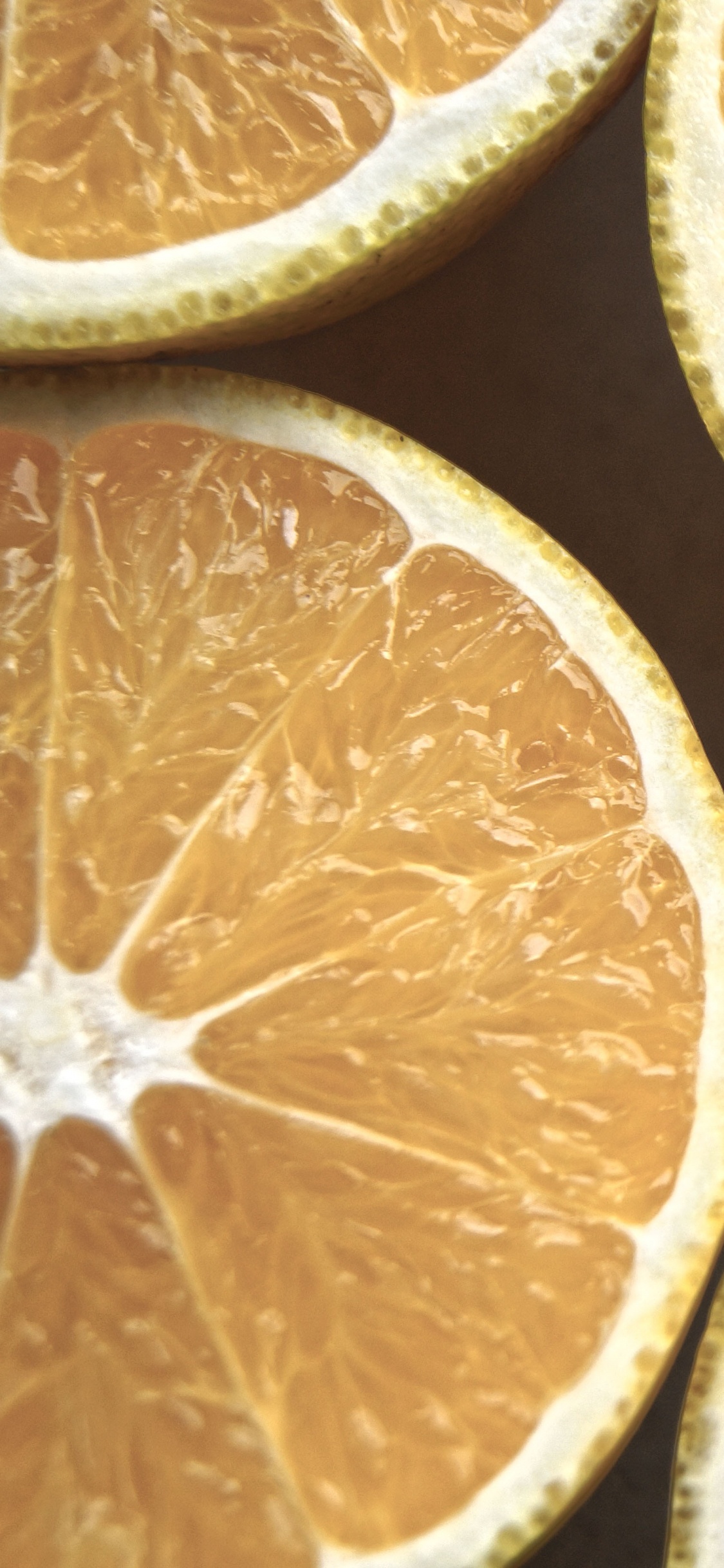 Fruta Naranja en Rodajas Sobre Superficie Negra. Wallpaper in 1125x2436 Resolution