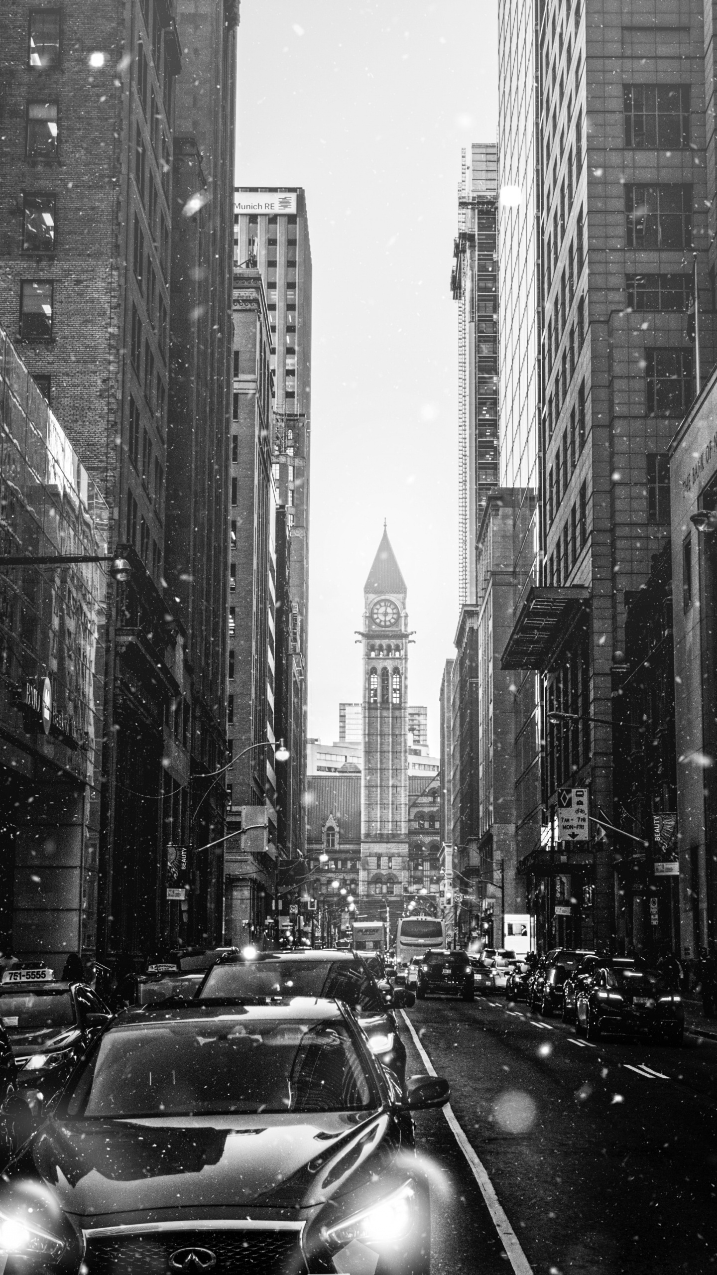 Grayscale Photo of Cars on Road Between High Rise Buildings. Wallpaper in 1440x2560 Resolution
