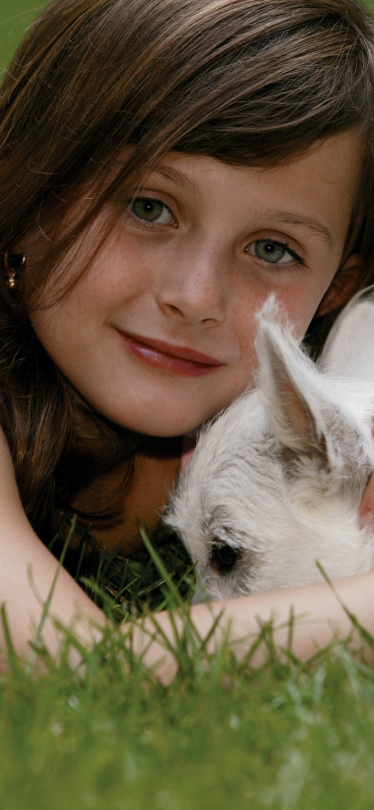 Woman Lying on Green Grass Field With White Cat. Wallpaper in 1242x2688 Resolution