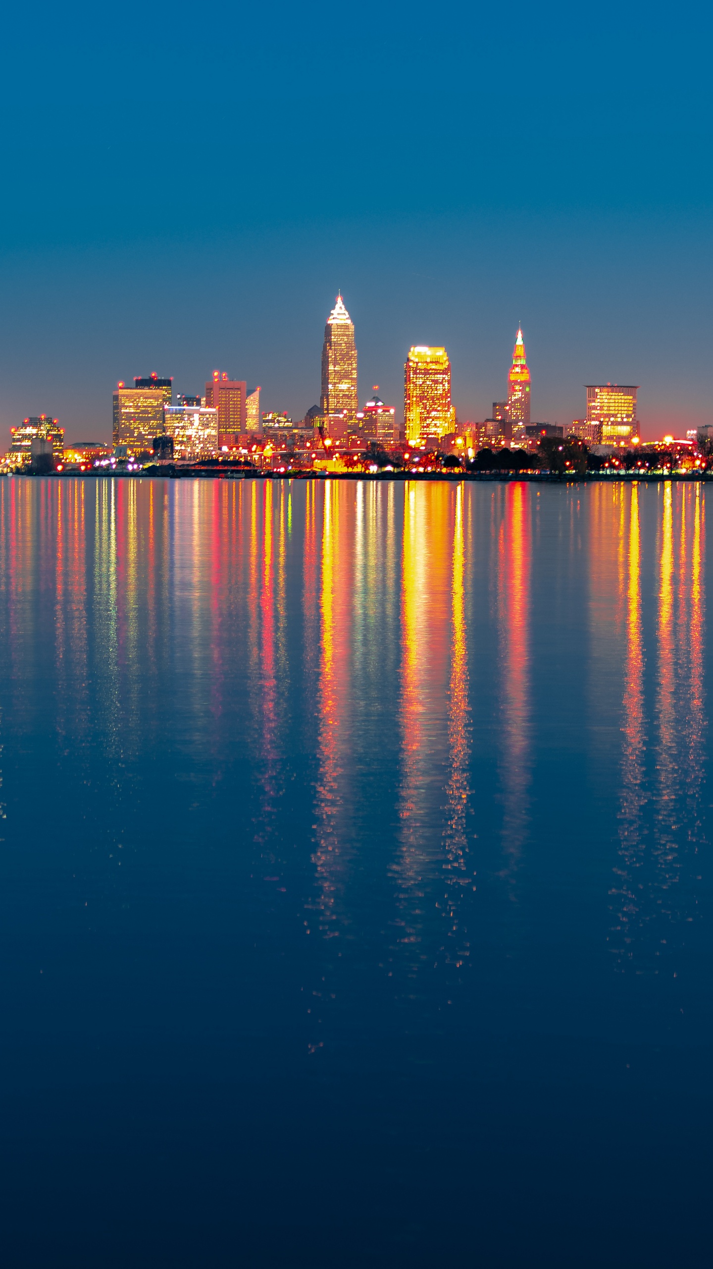 City Skyline Across Body of Water During Night Time. Wallpaper in 1440x2560 Resolution