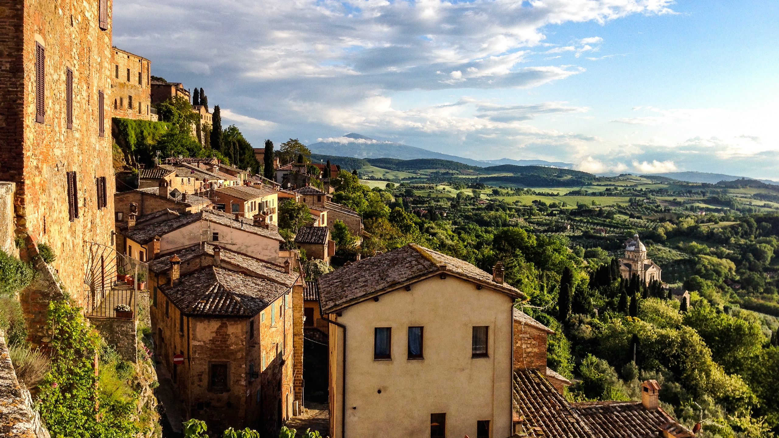 Brown Concrete Building Near Green Trees Under White Clouds During Daytime. Wallpaper in 2560x1440 Resolution