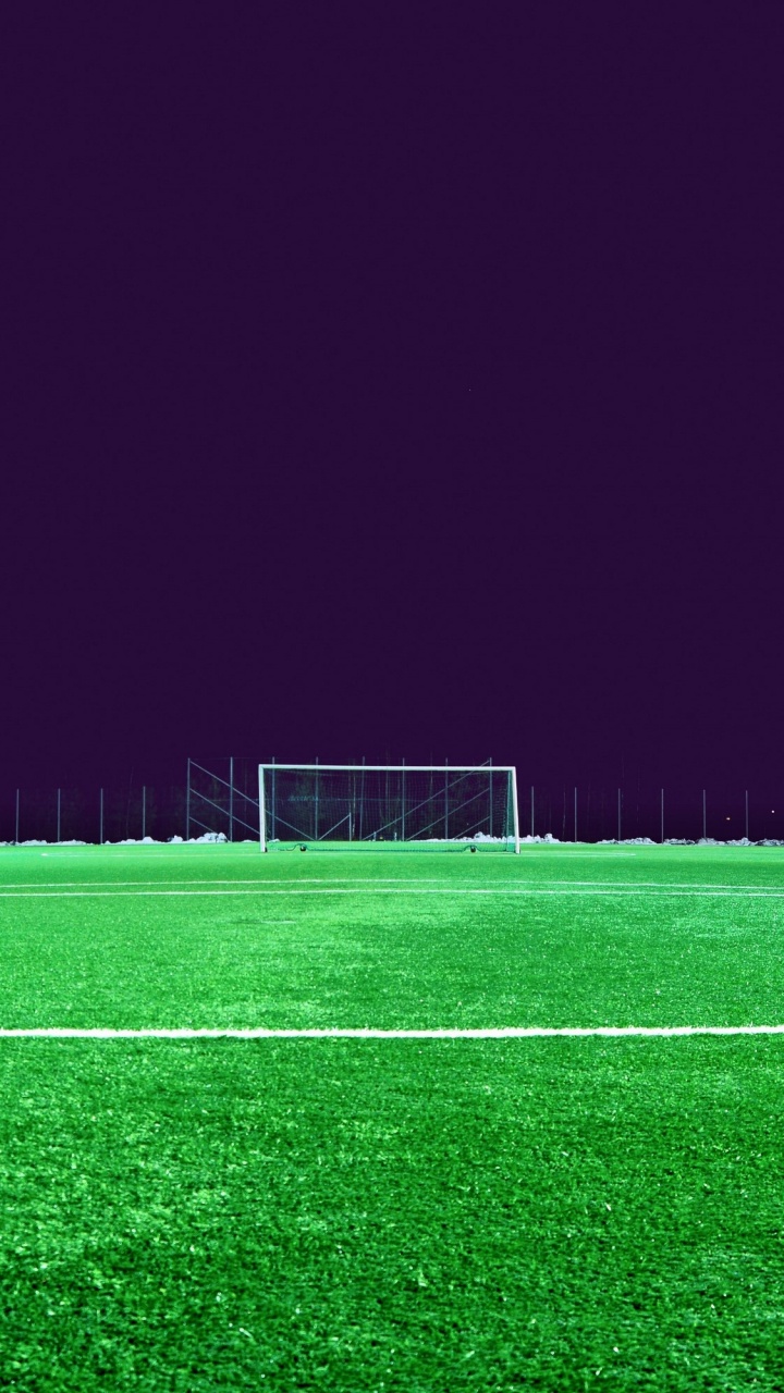 Fußballtornetz Auf Der Grünen Wiese Während Der Nacht. Wallpaper in 720x1280 Resolution