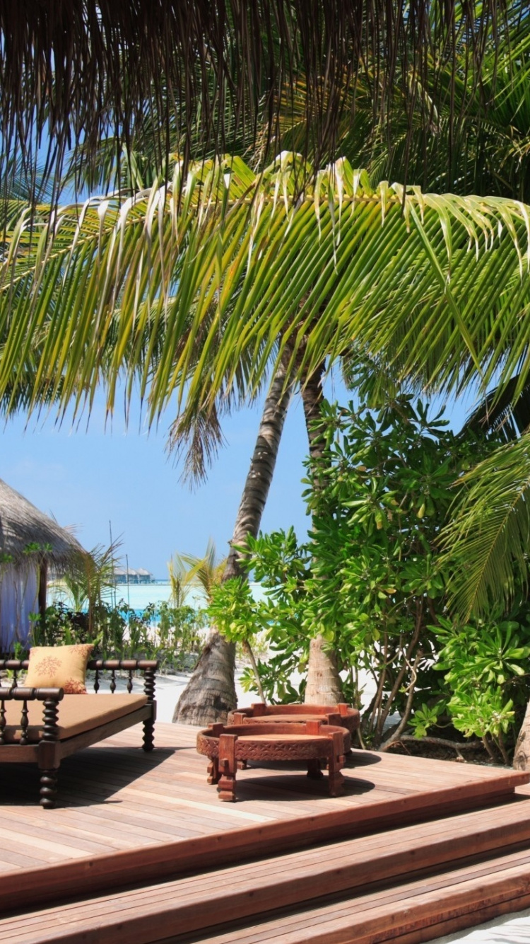 Chaises Longues en Bois Marron Sur la Plage Pendant la Journée. Wallpaper in 750x1334 Resolution