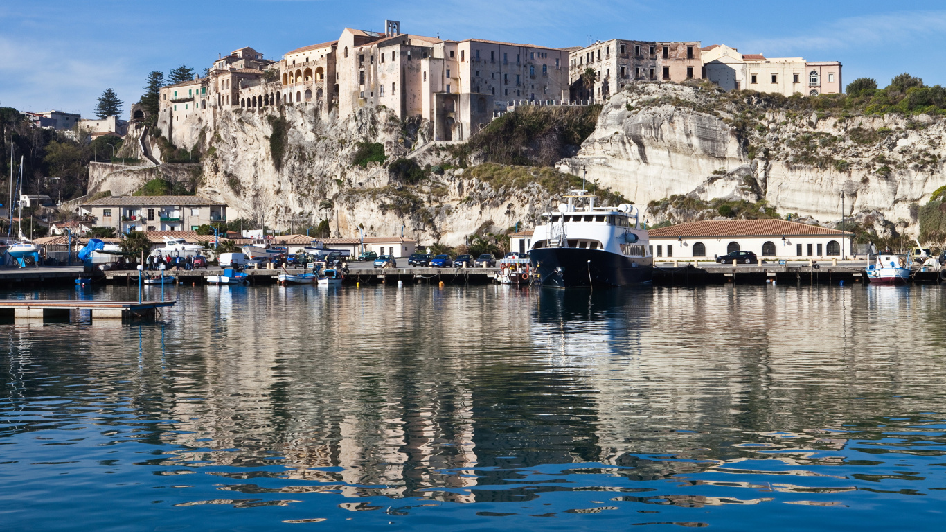 Bateau Blanc et Bleu Sur un Plan D'eau Près D'un Bâtiment en Béton Pendant la Journée. Wallpaper in 1366x768 Resolution