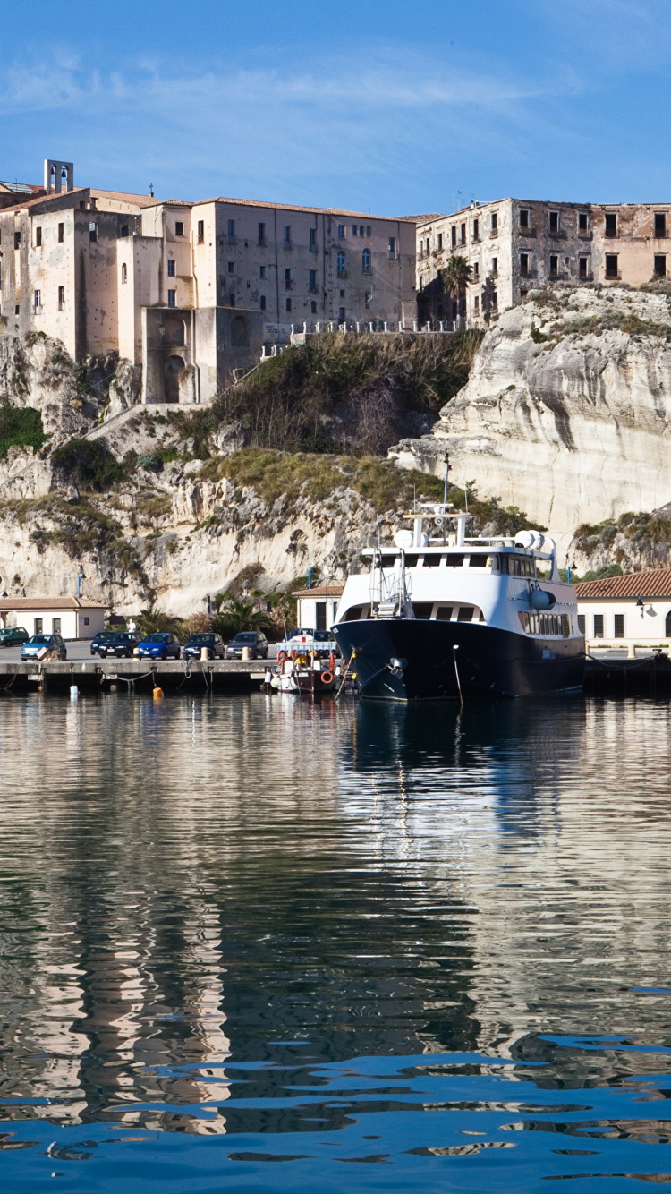 Bateau Blanc et Bleu Sur un Plan D'eau Près D'un Bâtiment en Béton Pendant la Journée. Wallpaper in 750x1334 Resolution