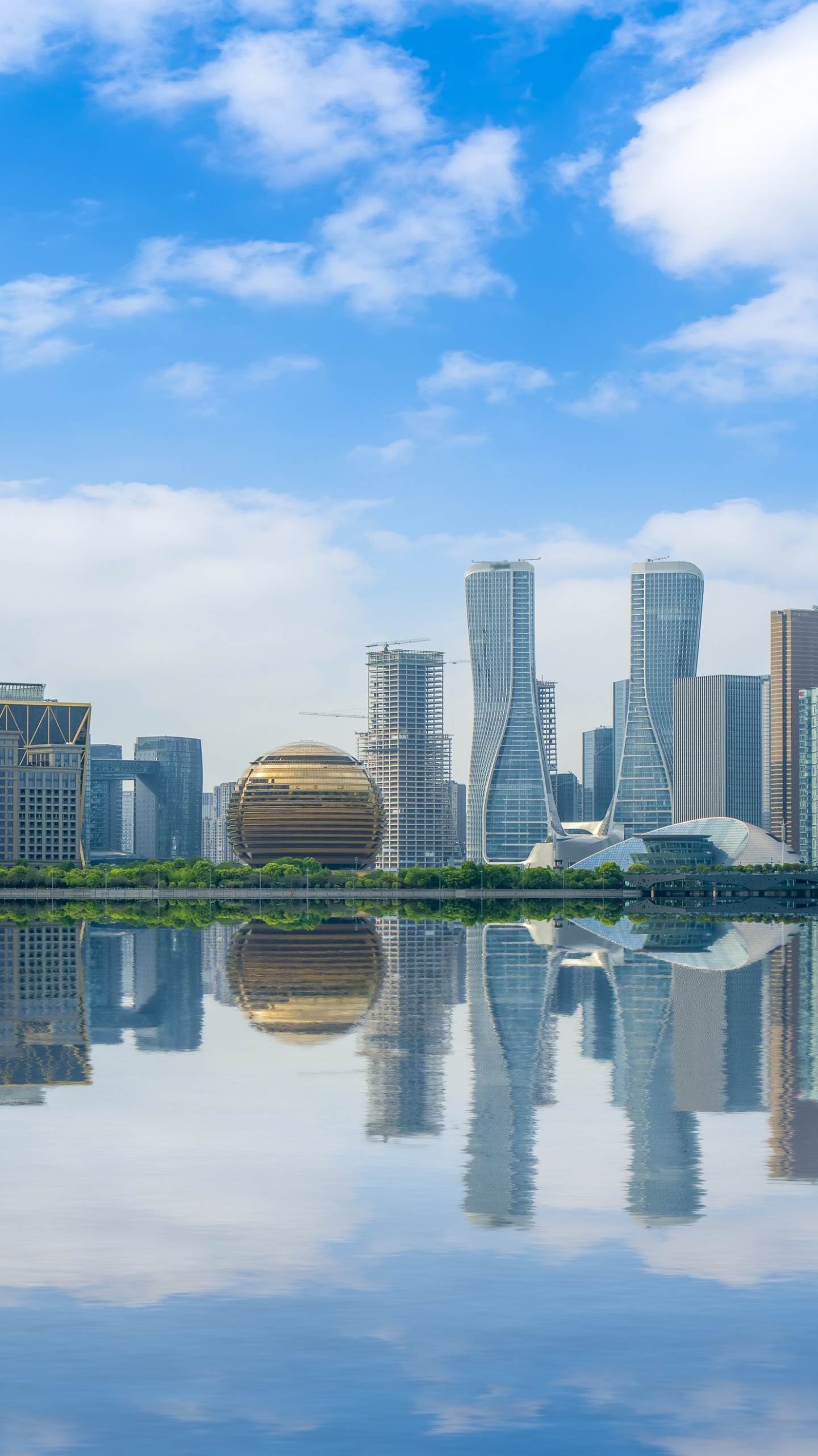 City Skyline Across Body of Water Under Blue and White Sunny Cloudy Sky During Daytime. Wallpaper in 1440x2560 Resolution