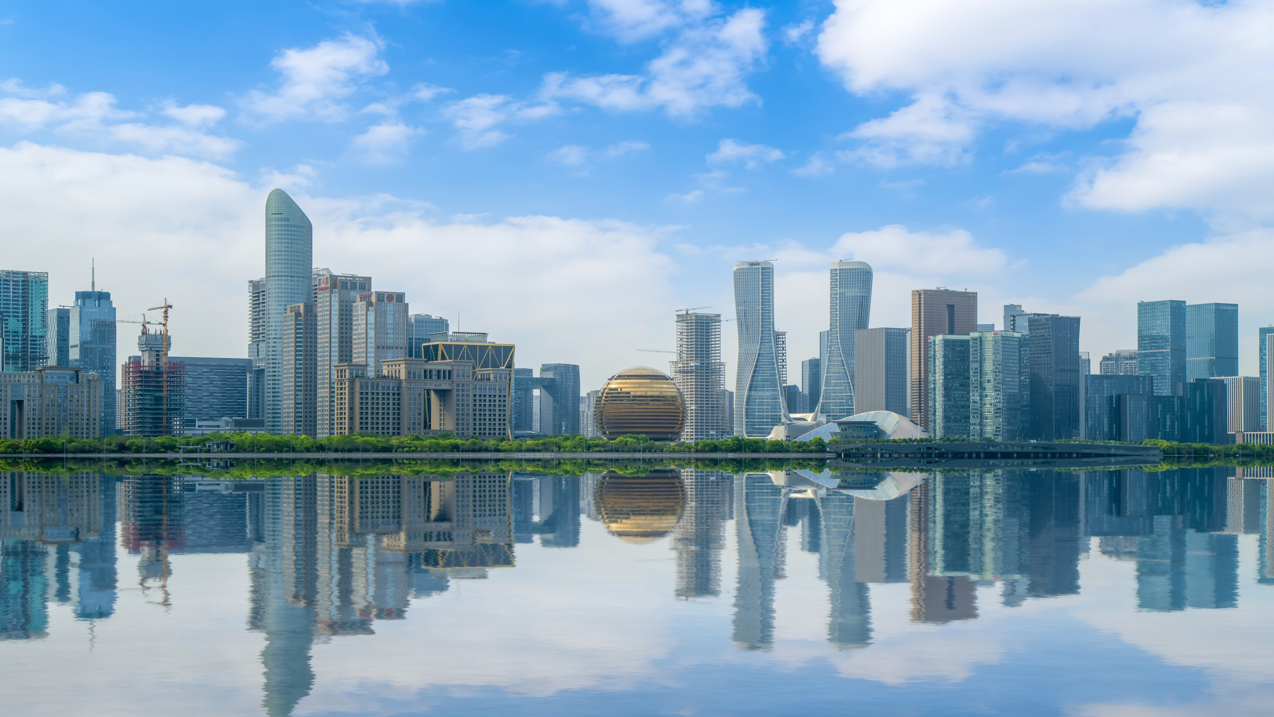 City Skyline Across Body of Water Under Blue and White Sunny Cloudy Sky During Daytime. Wallpaper in 2560x1440 Resolution
