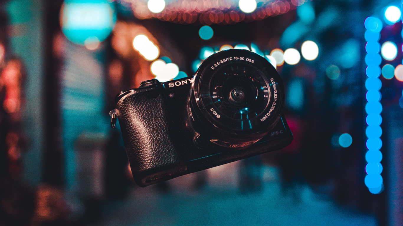Black Dslr Camera on Blue and White String Lights. Wallpaper in 1366x768 Resolution