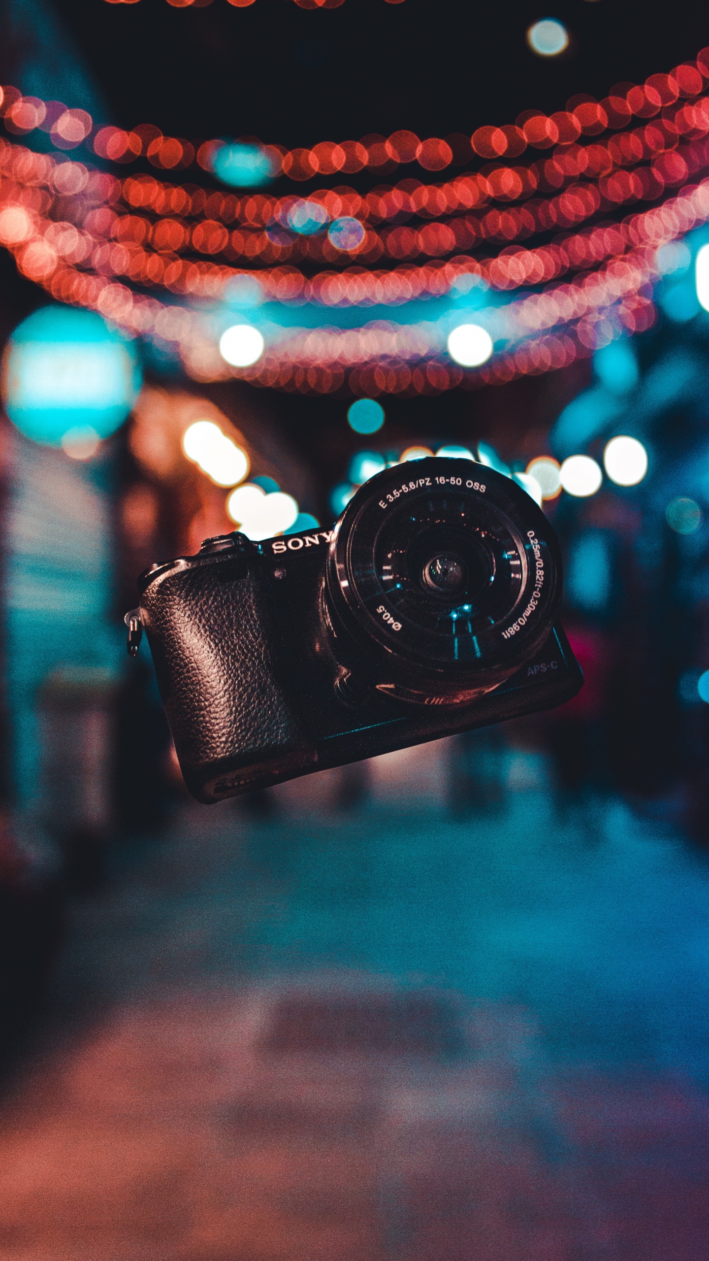 Black Dslr Camera on Blue and White String Lights. Wallpaper in 1440x2560 Resolution